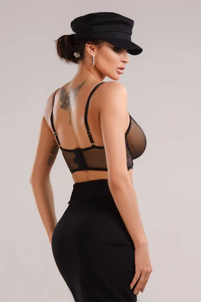 seksi genç güzel esmer kadın siyah şapka, etek ve sutyen giyiyor Studio'da poz 