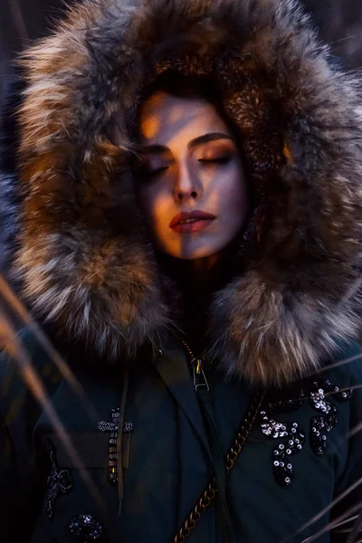 young beautiful woman in parka with fur hood posing