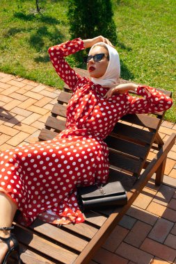  Güneş yatağında poz veren güzel bir kadın.