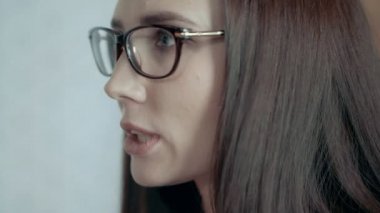 Gözlüklü genç Avrupa kadın takım lideri çehresini takım toplantısında memnuniyetsizlik ifade eder.