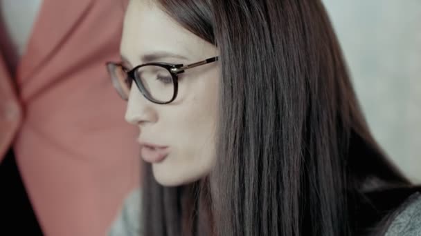 Sérieux et pensif jeune femme chef d'équipe dans les lunettes sourires et expériences émotions positives — Video