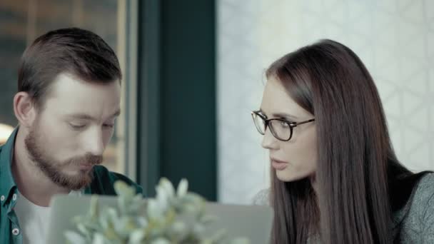 Líder de equipo femenino en gafas y joven programador masculino discutiendo el concepto de nuevo proyecto en la oficina — Vídeo de stock