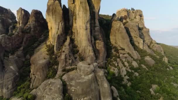Plano aéreo despegando sobre las montañas naturales de Meteora increíble paisaje al atardecer — Vídeo de stock