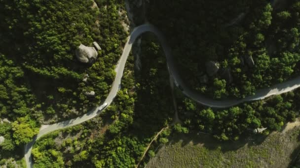 Plano aéreo volando sobre increíble valle natural con sinuoso camino de asfalto — Vídeo de stock