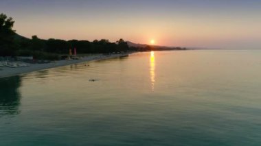 Hava atış muhteşem panoramik deniz ve plaj yüksek ağaçlar ve rahatlatıcı turist günbatımında sakin