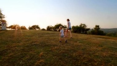 Etkin aile Genç Anne ve engebeli arazi günbatımında hiking dağda yürüyüş mutlu küçük oğlu