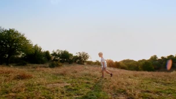 Niño Activo Corriendo Disfrutando Prado Atardecer Seguimiento Cámara Lenta Tiro — Vídeos de Stock