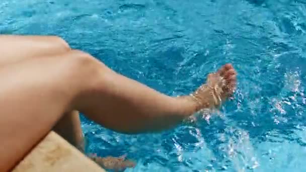 Yüksek açı yakın çekim Kadın güneşlenme bacaklar oynarken zevk berrak yüzme havuzunda saf su — Stok video