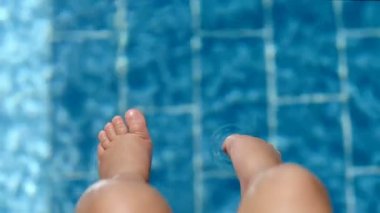 Üstten görünüm yakın çekim bacaklar splash saf suda yapma havuz kenarı oturan şirin bebek tabaklanmış