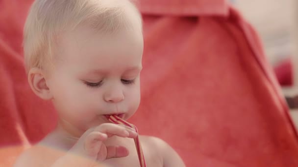 Close-up portret van Europese peinzende kindje het drinken van vers sap met behulp van stro kid gezicht — Stockvideo
