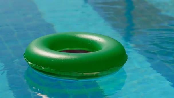 Bouée de sauvetage verte à angle élevé flottant dans une piscine extérieure vide belle surface d'eau calme — Video