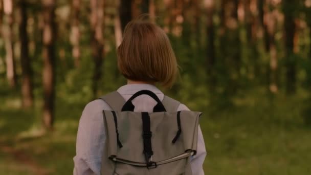 Indietro vista spensierata zaino in spalla attiva donna godendo a piedi nel verde foresta estiva — Video Stock