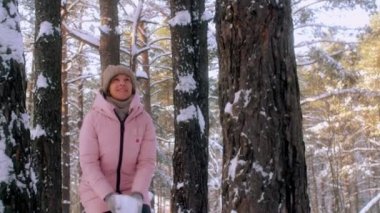 Eğleniyor düşük açılı kaygısız gülümseyen kadın beyaz temiz kar taneleri orman park slowmo savurma