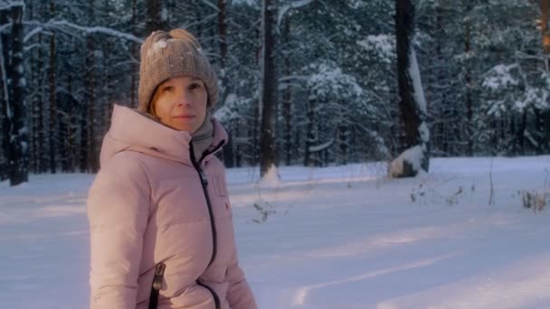 Medium shot portret van lachende teenage vrouw het dragen van warme muts en jas camera kijken — Stockvideo