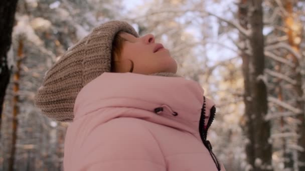 모자와 재킷 머리 위로 상승 하 고 놀라운 높은 나무를 감상 하는 젊은 여성을 집중 — 비디오