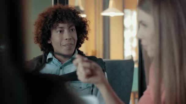 African Man écoute le discours d'une femme gesticulant activement discutant d'un projet de démarrage au bureau 