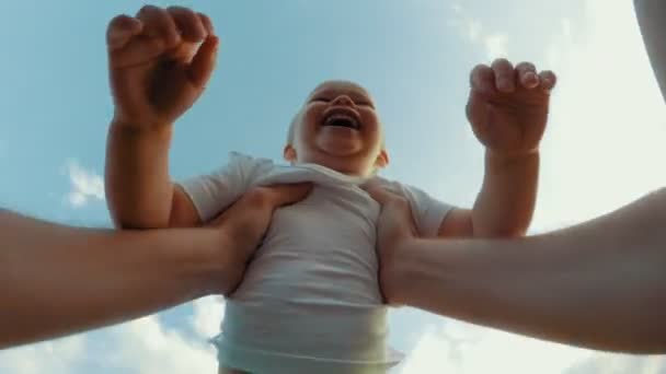 気楽な父親の手が立ち上がり、背景に小さなかわいい笑顔の息子の空を紡ぐポブショット — ストック動画