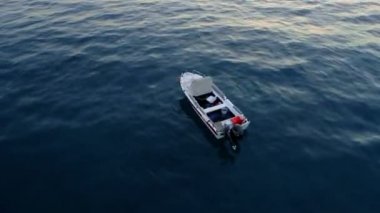 Havadan hızlı rotasyon küçük balıkçı teknesi yukarıdan sakin koyu mavi deniz görünümünde limanda vurdu