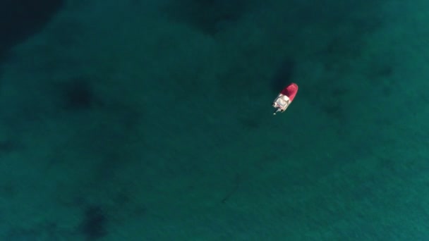 Vue aérienne statique solitaire bateau vide entouré d'une vue dégagée sur l'eau de mer turquoise d'en haut — Video