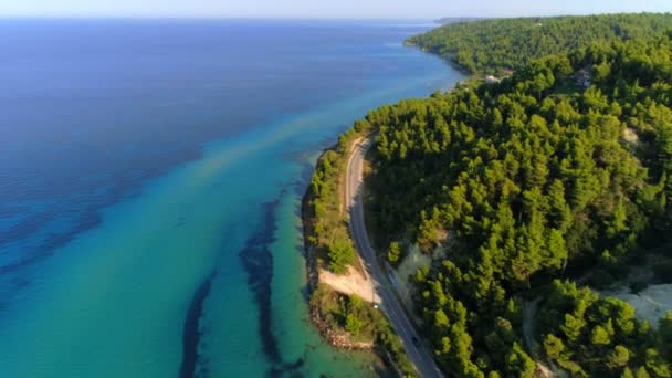 空中ショットは、ギリシャの夕日に美しいクリア無限の海に囲まれた素晴らしい熱帯の島を離れて移動します — ストック動画