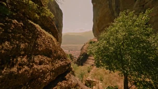 暑い晴れた夏の日に素晴らしい自然の風景を楽しんで2つの高い岩の間を移動するポブショット — ストック動画