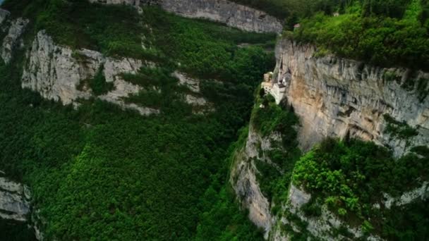 Volando sobre el valle del paisaje natural cubierto por el bosque verde fresco plano aéreo templo medieval — Vídeo de stock