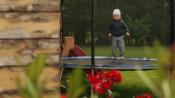 Happy child jumping on trampoline having fun outdoor funny playful baby boy enjoying freedom — Stock Video