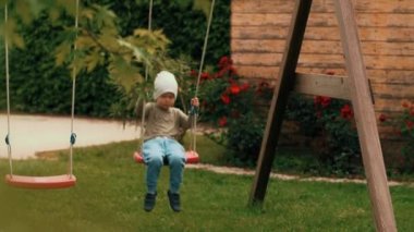 Mutlu rahat çocuk çocuk oyun yavaş hareket iyi vakit geçirerek salıncak sallanan rahatlatıcı