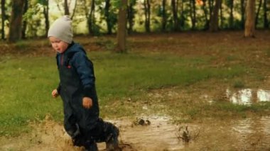 Sevimli küçük bebek kirli su birikintisi üzerinde çalışan yaz orman parkı çocuk çocuk yürüme keyfini