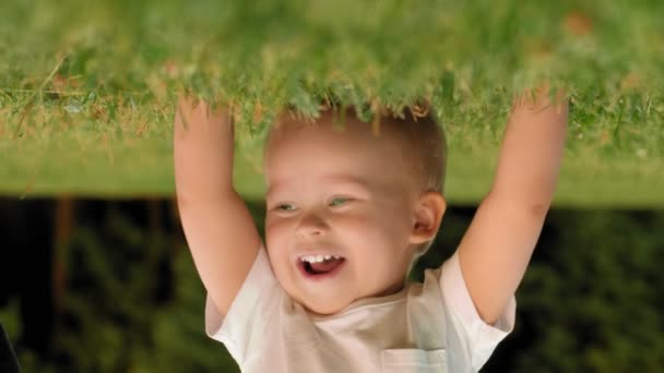 Close-up gezicht weinig glimlachend schattig kind met plezier staande door handen ondersteboven hoofd — Stockvideo