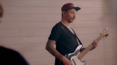 Erkek rock yıldızı duygusal olarak hareketli, bas gitaristin elektro gitar çalmasından keyif alıyor.