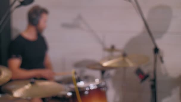 Jeune batteur masculin moderne déconcentré finissant la performance rock en enlevant les écouteurs au studio de musique — Video