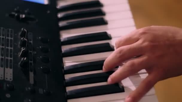 Primer plano de las manos del teclista masculino tocando en el piano o sintetizador durante la actuación de rock — Vídeo de stock