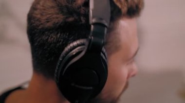 Yakın plan odaklı, kulaklık takan davulcu davul çalarken müzik dinlemekten zevk alıyor.