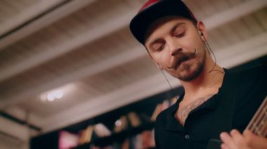 Çekici dövmeli basçı duygusal olarak elektro bas gitar ve rock performansı çalıyor.