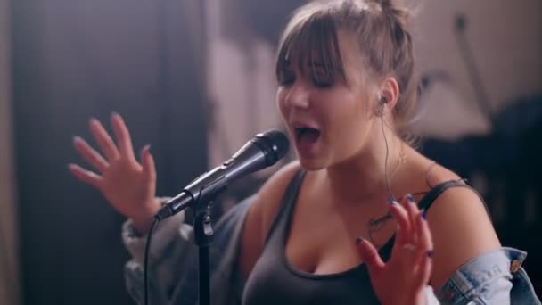Inclinación de talentosa joven solista cantando en el micrófono y gesticulando en la actuación de rock — Vídeos de Stock