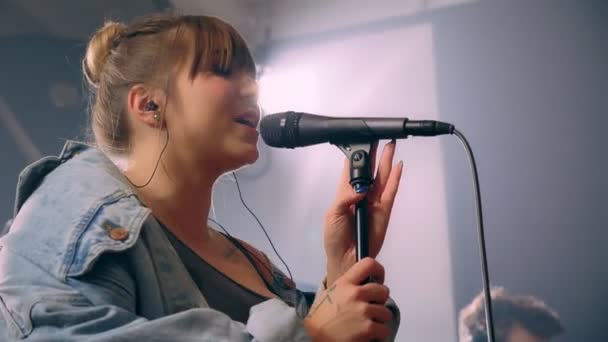 Emocional joven caucásica mujer solista entusiasta canto canción en micrófono rock rendimiento — Vídeo de stock