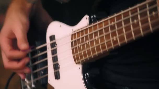 Primer plano de manos bajistas masculinos tocando en el bajo eléctrico tocando cuerdas en el rendimiento de rock — Vídeo de stock