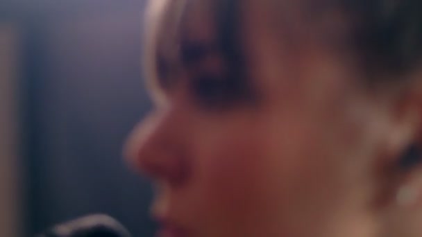 Close-up face of beautiful talented young European woman singing song on microphone side view — Stock Video