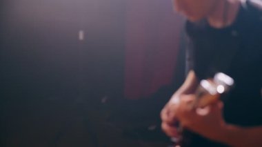 Stüdyo rock performansında elektro gitaristin yakın çekim elleri.
