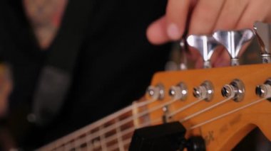 Rock müzisyeninin yakın çekim erkek elleri elektro bas gitar akortları rock performansı