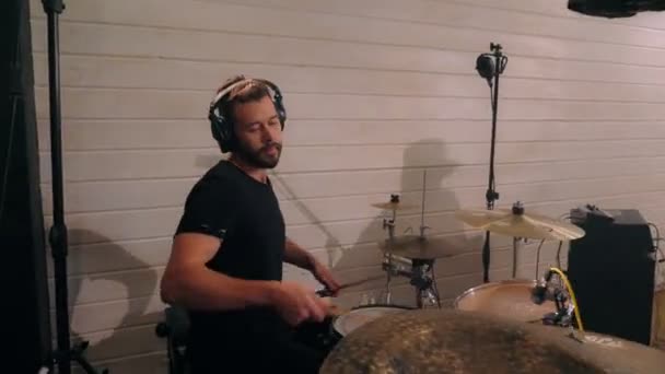 Enthusiastic drummer hitting on drum cymbal using drumsticks playing on live session in studio — Stock Video