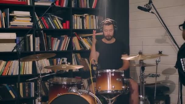 Entusiástico caucasiano jovem baterista masculino emocionalmente tocando no tambor usando bastões de bateria tiro completo — Vídeo de Stock