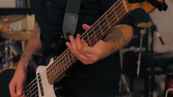 Close-up man handen dragen tatoeage professionele bassist spelen op bas gitaar rock prestaties — Stockvideo