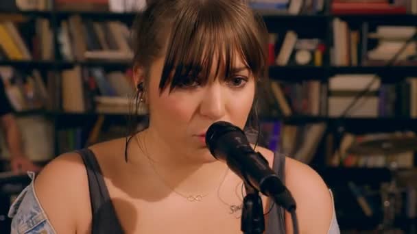 Chanteuse soliste enthousiaste chantant émotionnellement une chanson dans la performance d'un groupe de microphone rock — Video