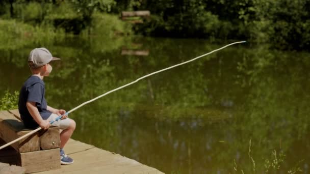 Bonito bebê menino sentado no cais com vara de pesca espera pegar aproveitando fim de semana — Vídeo de Stock