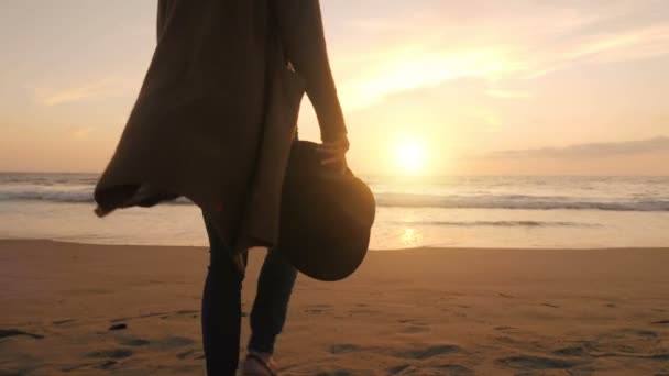 폼 웨이브 에서 멀어 져 가는 바닷물 속으로 천천히 움직이는 파도를 향해 해변을 걷고 있는 긴장 한 여인 — 비디오