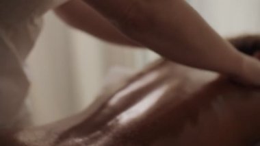 Aşırı yakın çekim kılavuz terapisti rahatlama işlemi sırasında dişiye yağ ile masaj yapıyor.