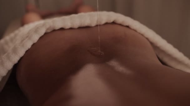 Versando flusso di caldo massaggio olio per sexy nudo abbronzato femmina indietro a spa bellezza salone — Video Stock