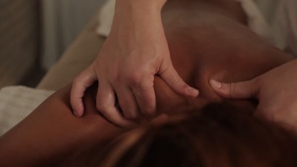 Professional woman masseur hands massaging neck and back muscles of relaxed female client body massage — Stock Video